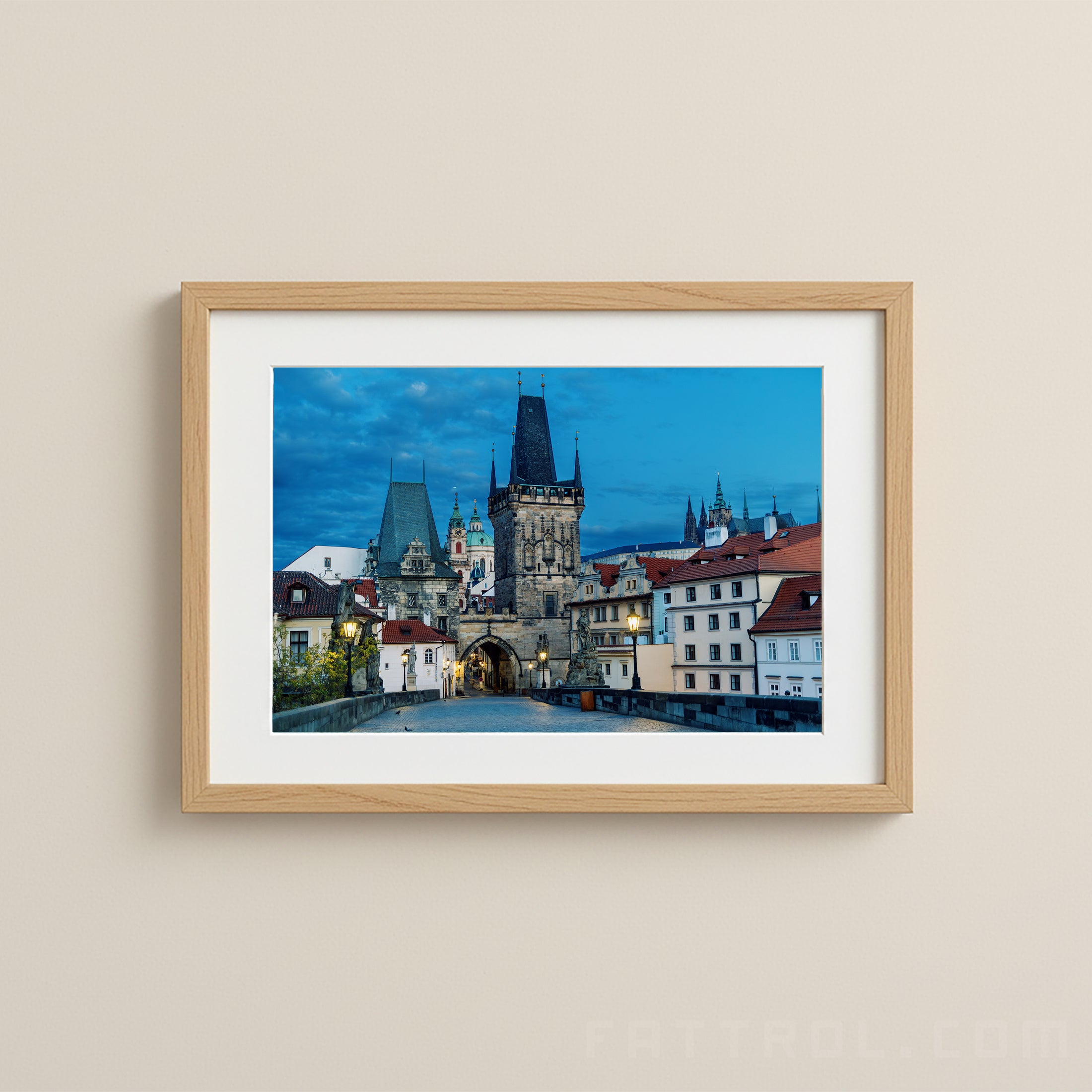 Framed photograph of a cityscape with a prominent tower on a beige wall.