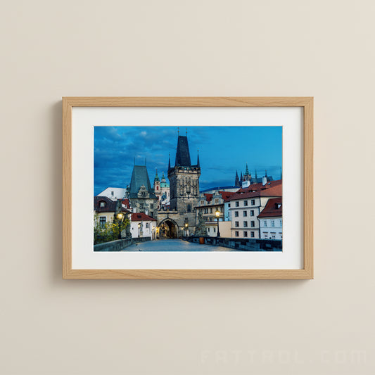 Framed photograph of a cityscape with a prominent tower on a beige wall.