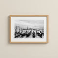 Load image into Gallery viewer, Framed black and white photograph of gondolas on a canal with a cityscape in the background.

