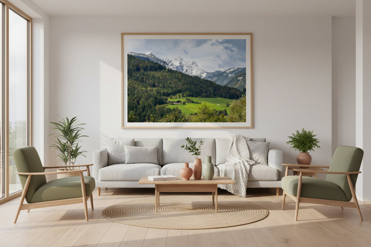 Modern living room with a gray sofa, green armchairs, and a mountain landscape painting.