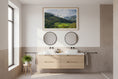 Load image into Gallery viewer, Bathroom with wooden vanity, round mirrors, and a scenic wall art
