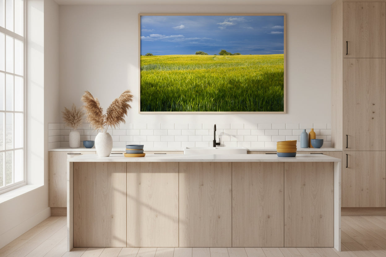 Modern kitchen with a large framed picture of a green field on the wall.