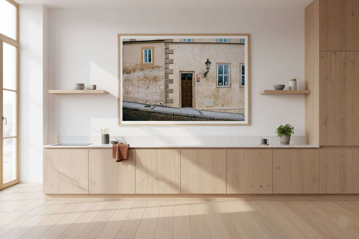 Modern kitchen with wooden cabinets and a framed photograph on the wall.