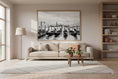 Load image into Gallery viewer, Living room with a beige sofa, coffee table, and wall art of a cityscape.
