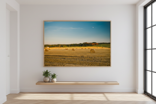 Countryside panorama with hay bales and moon over the horizon