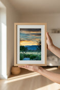 Load image into Gallery viewer, Framed landscape print held by a person in a softly lit room
