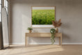 Load image into Gallery viewer, Modern interior with a wooden console table, decorative plants, and a framed picture of a green field.
