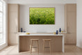 Load image into Gallery viewer, Modern kitchen with wooden cabinets, a white island, and a painting of a green field.
